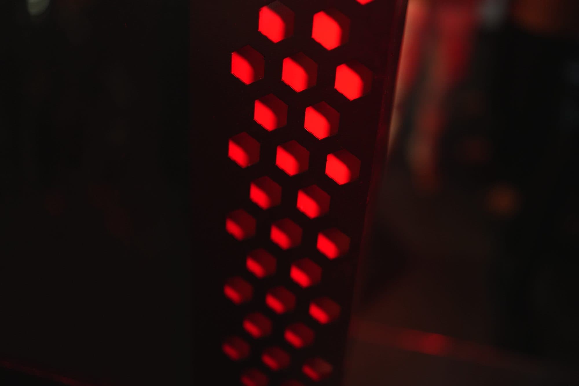 The kiosk in silhouette with its hex vent panel glowing red